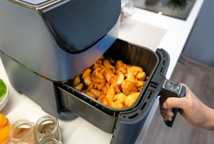 donna che usa friggitrice ad aria per cucinare