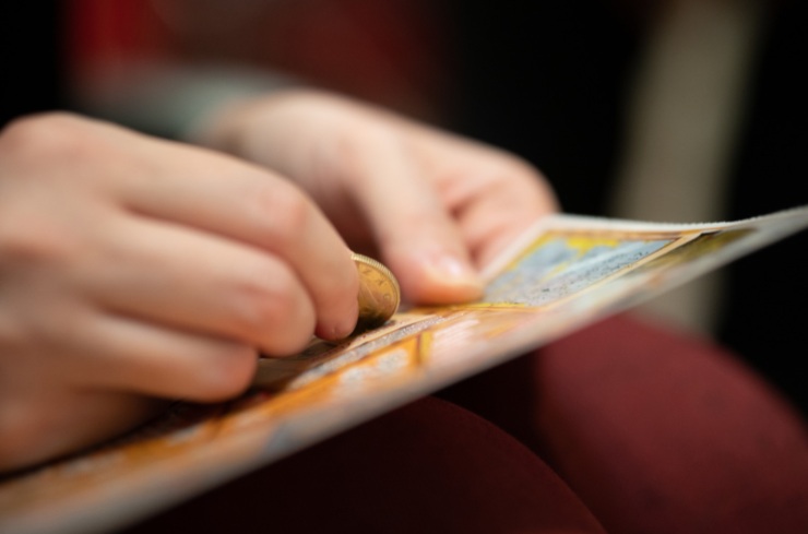 donna che gratta un biglietto del gratta e vinci