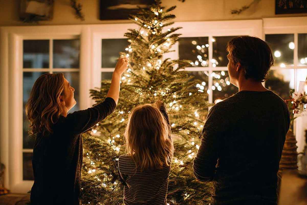 famiglia che fa l'albero di natale in salone