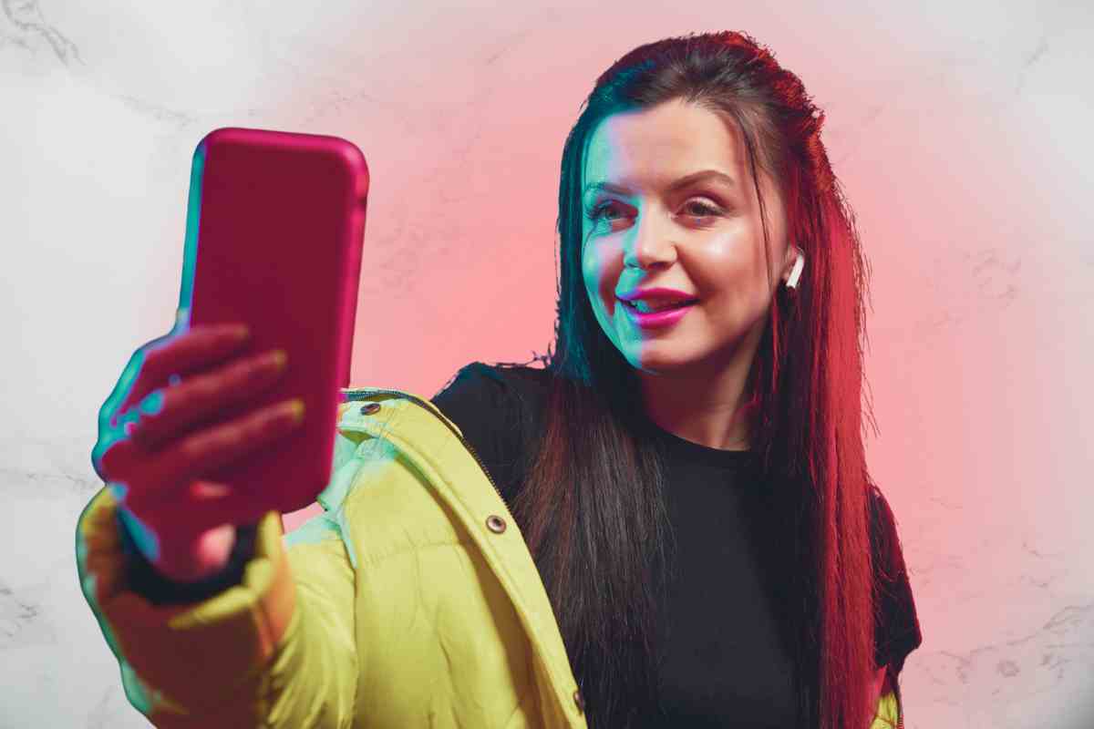 ragazza con bei capelli che si riprende conlo smartphone