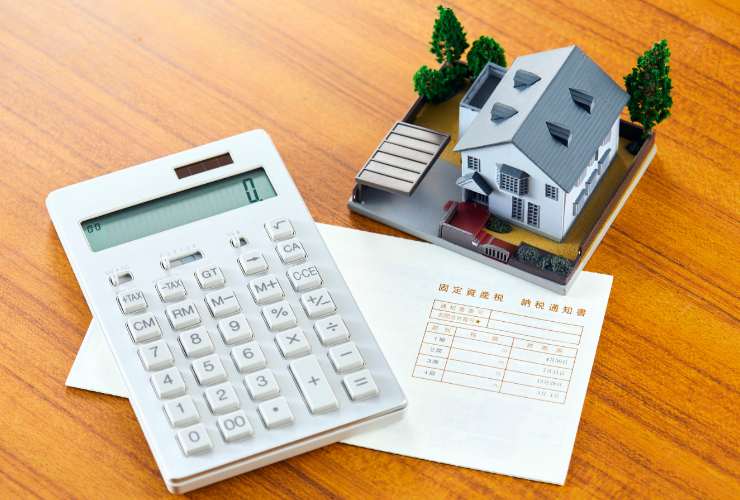 casa in miniatura, calcolatrice e documenti