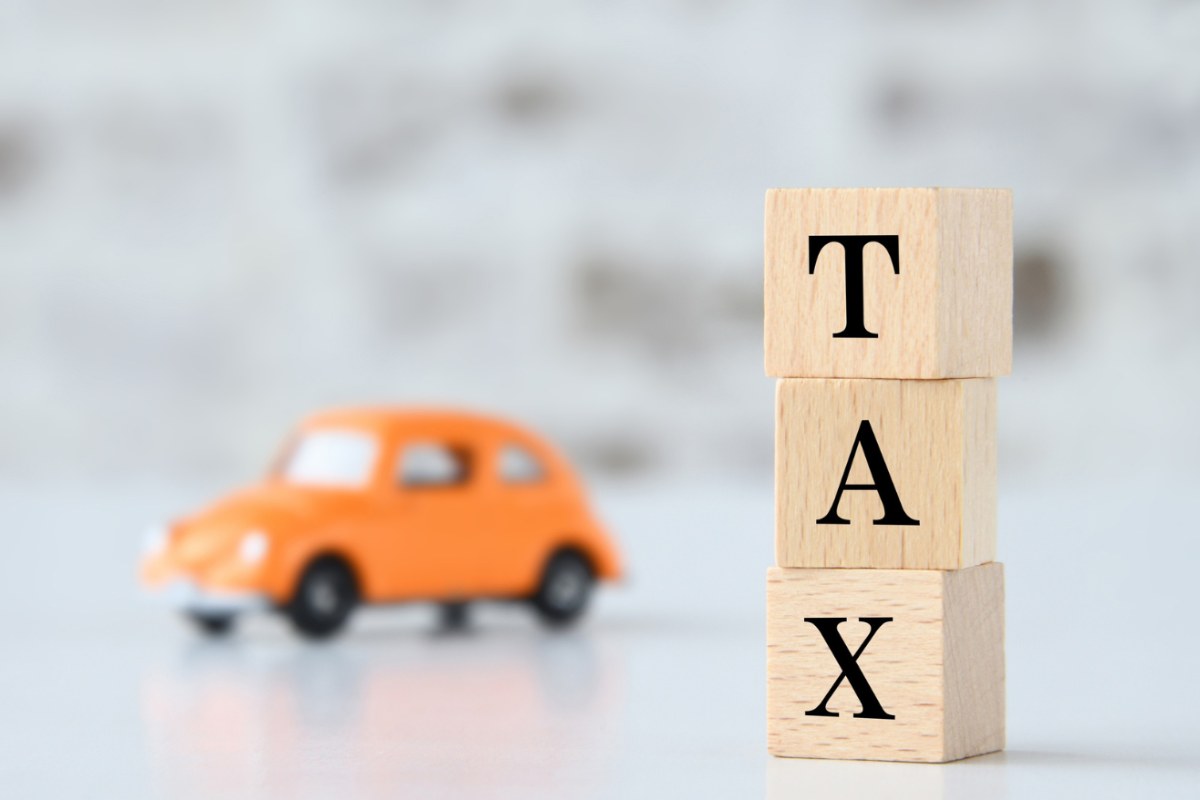 macchina in miniatura e scritta tasse