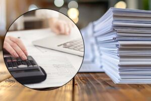 mano con calcolatrice e fogli vari