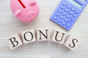 la scritta bonus con un salvadanaio vicino e una calcolatrice