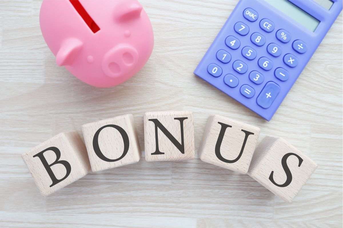 la scritta bonus con un salvadanaio vicino e una calcolatrice