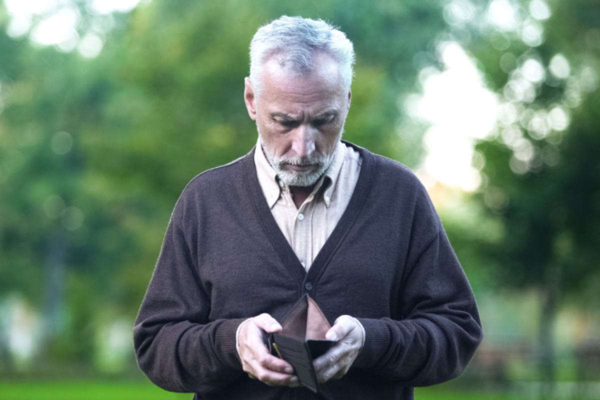 uomo triste con in mano un portafoglio vuoto